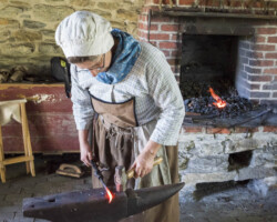 A blacksmith forms some iron work.