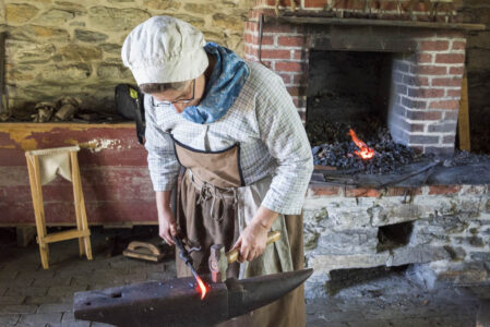 A blacksmith forms some iron work.